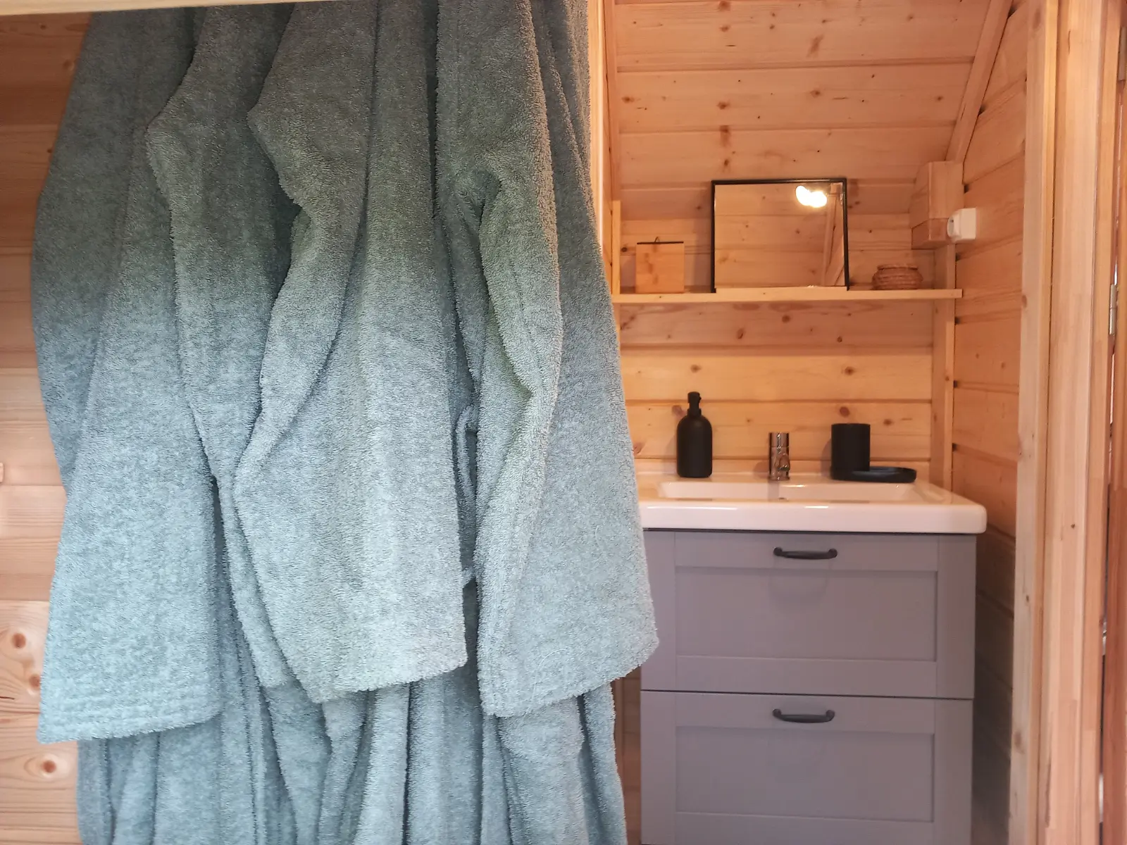 Jacuzzi extérieur en bois sur terrasse avec pergola, dans un jardin verdoyant