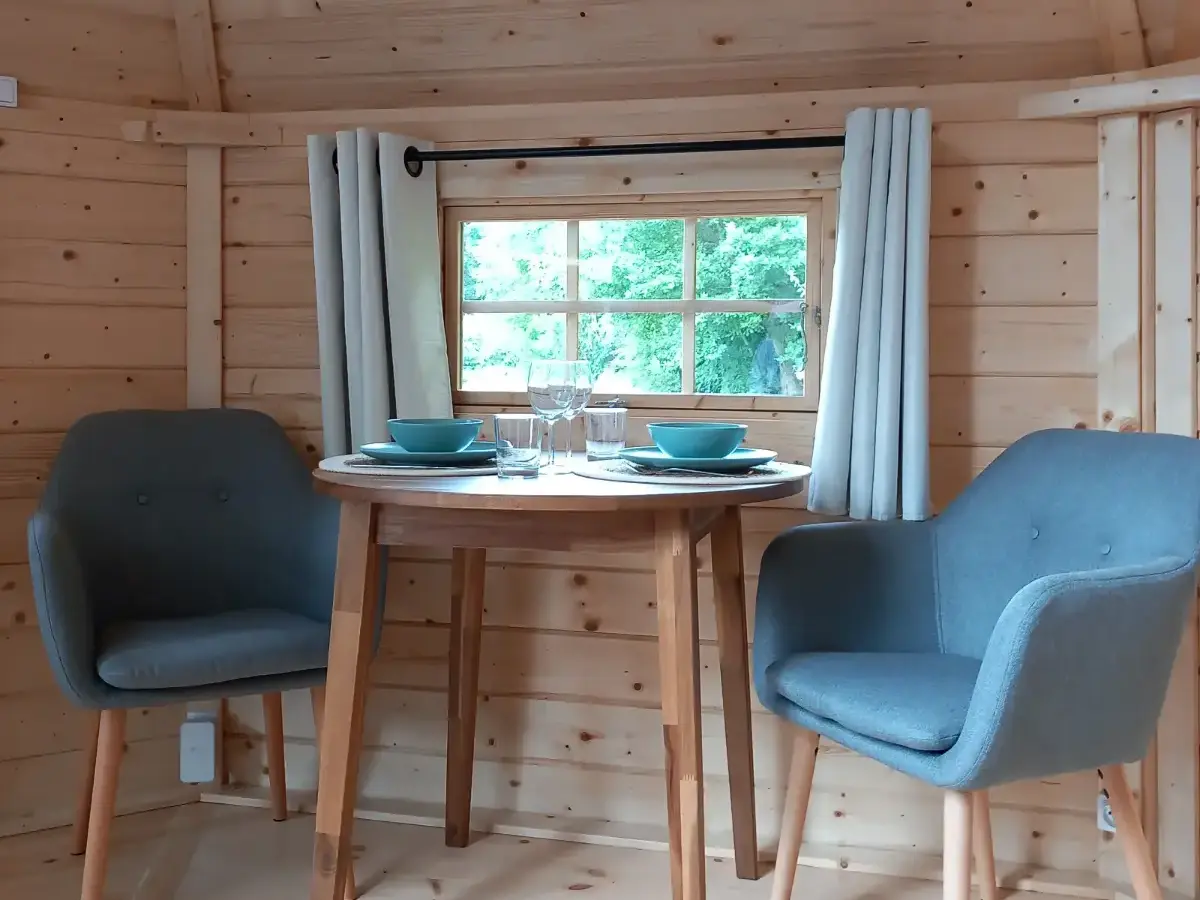 Jacuzzi extérieur en bois sur terrasse avec pergola, dans un jardin verdoyant