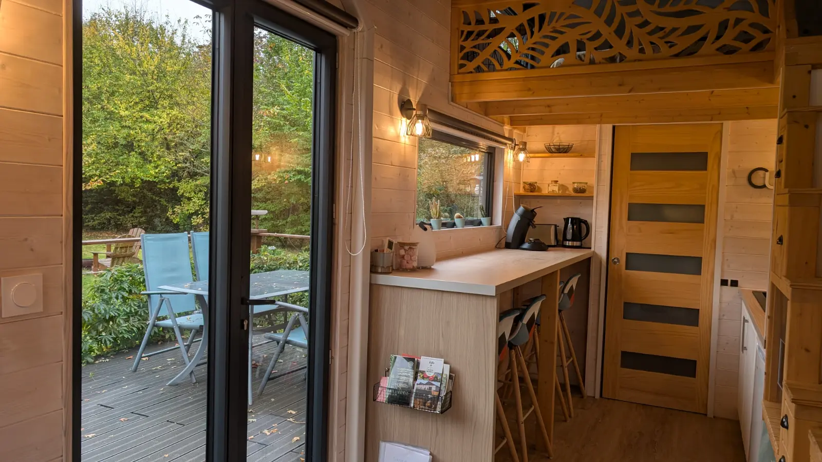 Gîte moderne en bois avec terrasse aménagée, jacuzzi et pergola dans un jardin