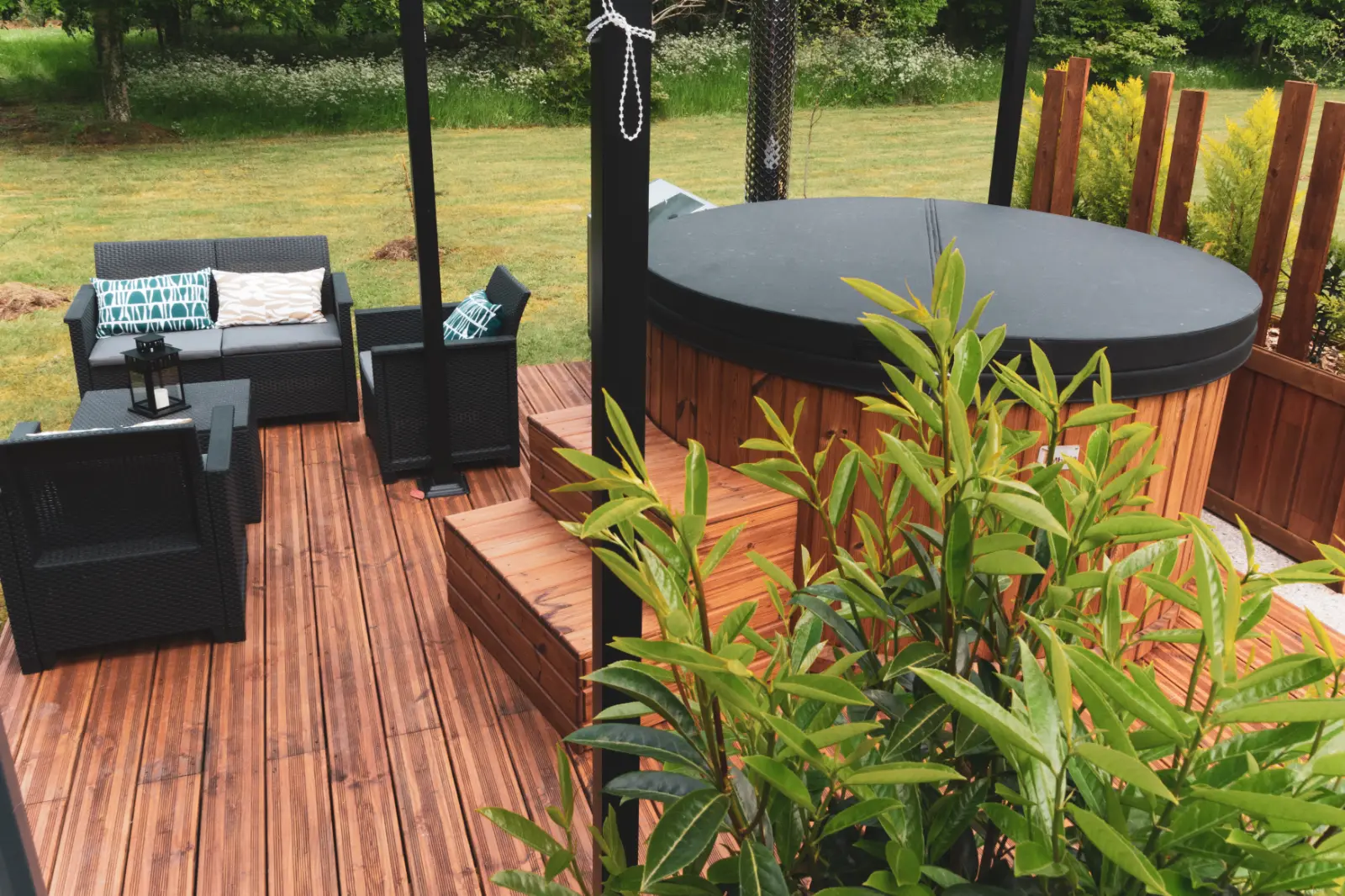 Gîte moderne en bois avec terrasse aménagée, jacuzzi et pergola dans un jardin