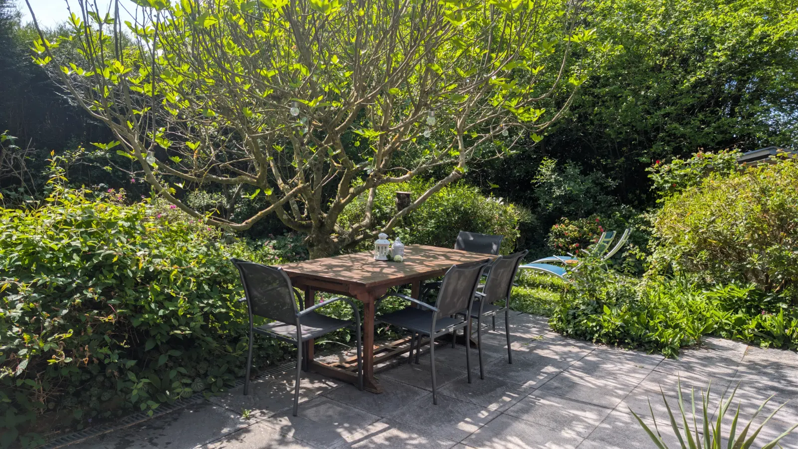 Brasero extérieur avec feu de bois dans un jardin aménagé, ambiance chaleureuse et conviviale