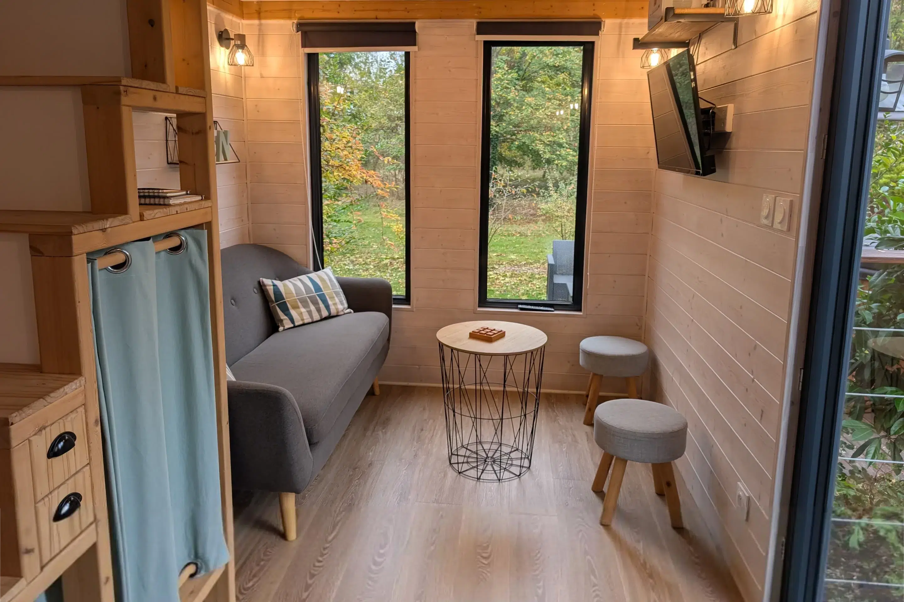 Terrasse en bois avec transats et jardin autour d’un gîte moderne