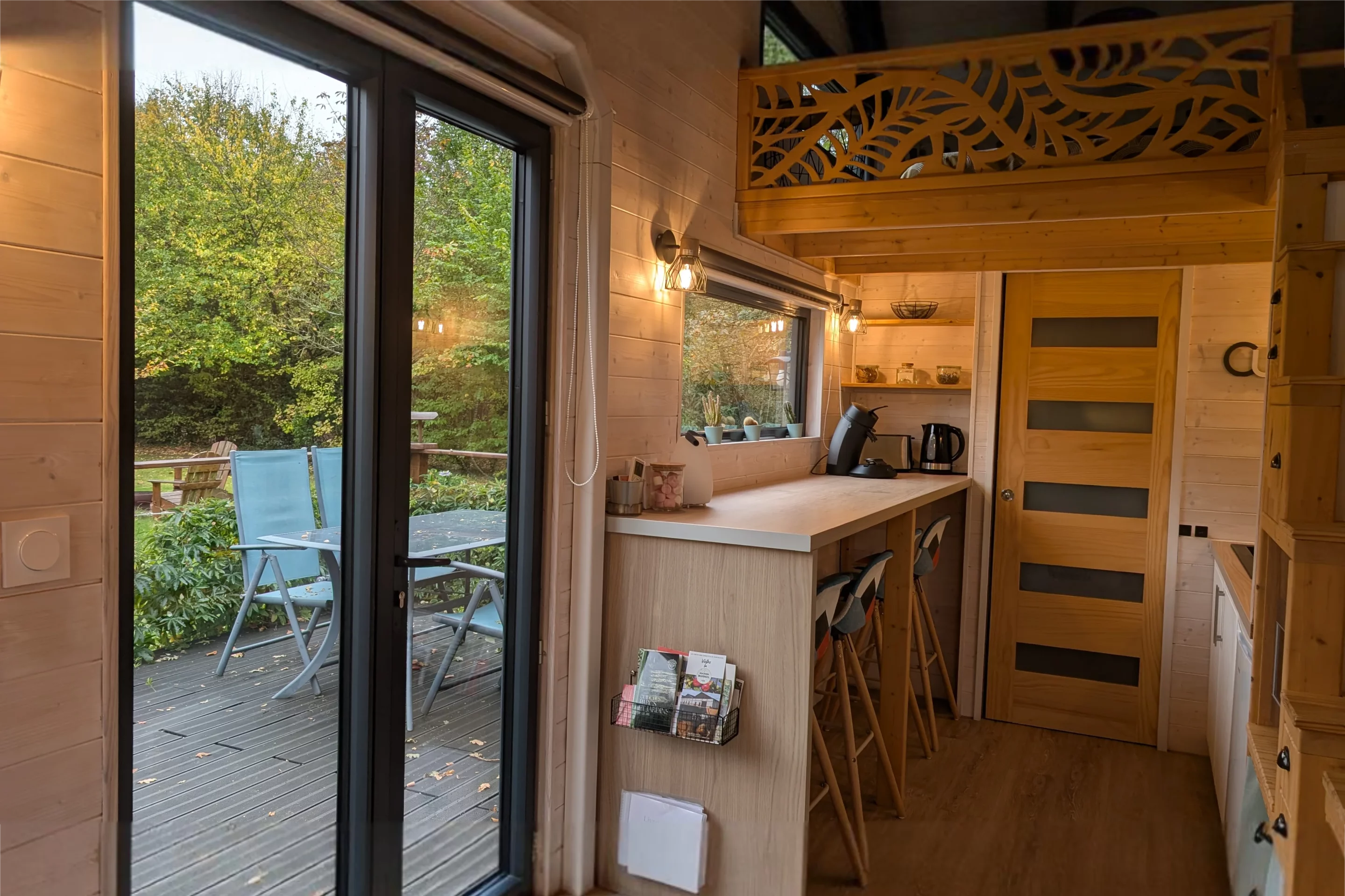 Terrasse en bois avec transats et jardin autour d’un gîte moderne