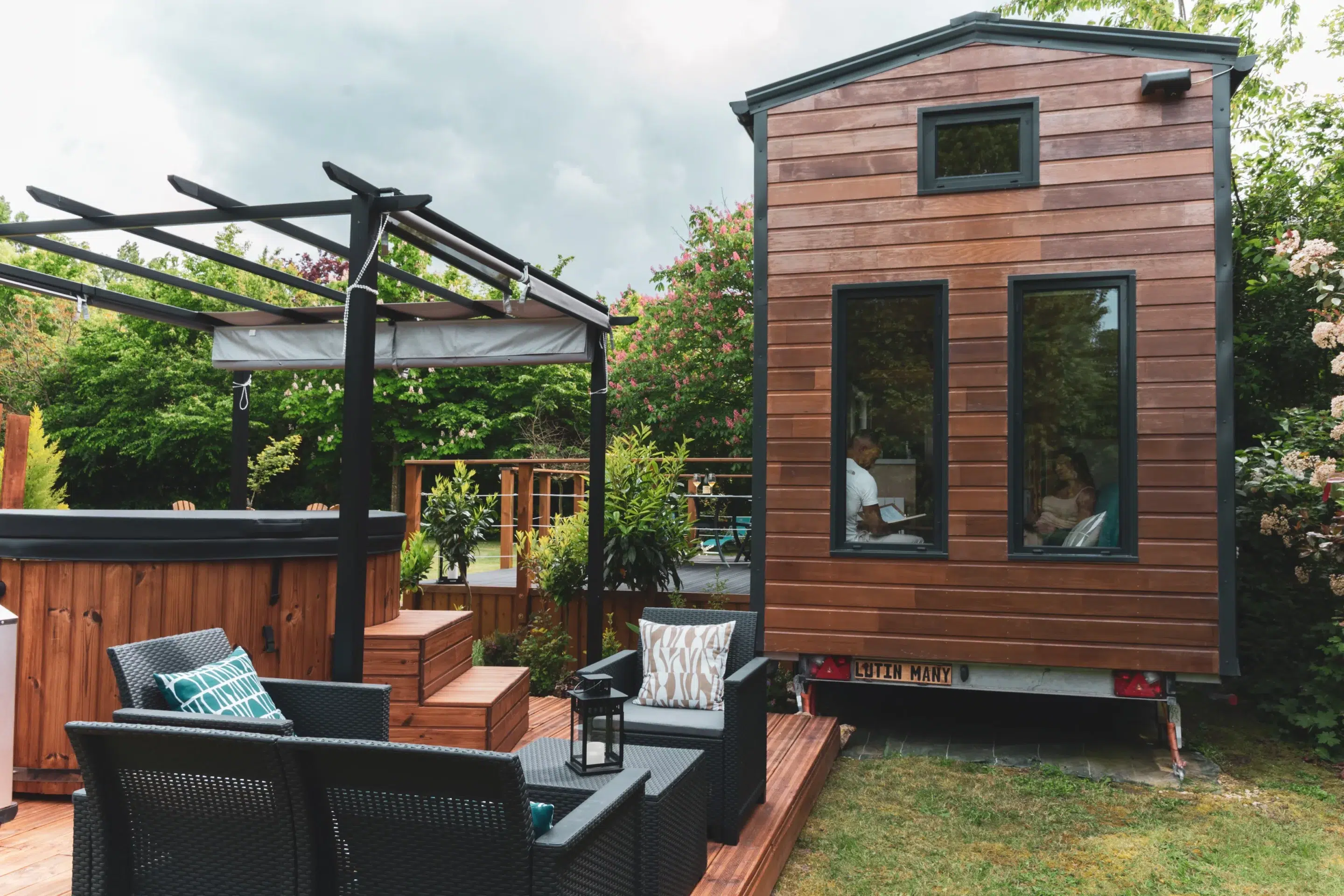 Terrasse en bois avec transats et jardin autour d’un gîte moderne