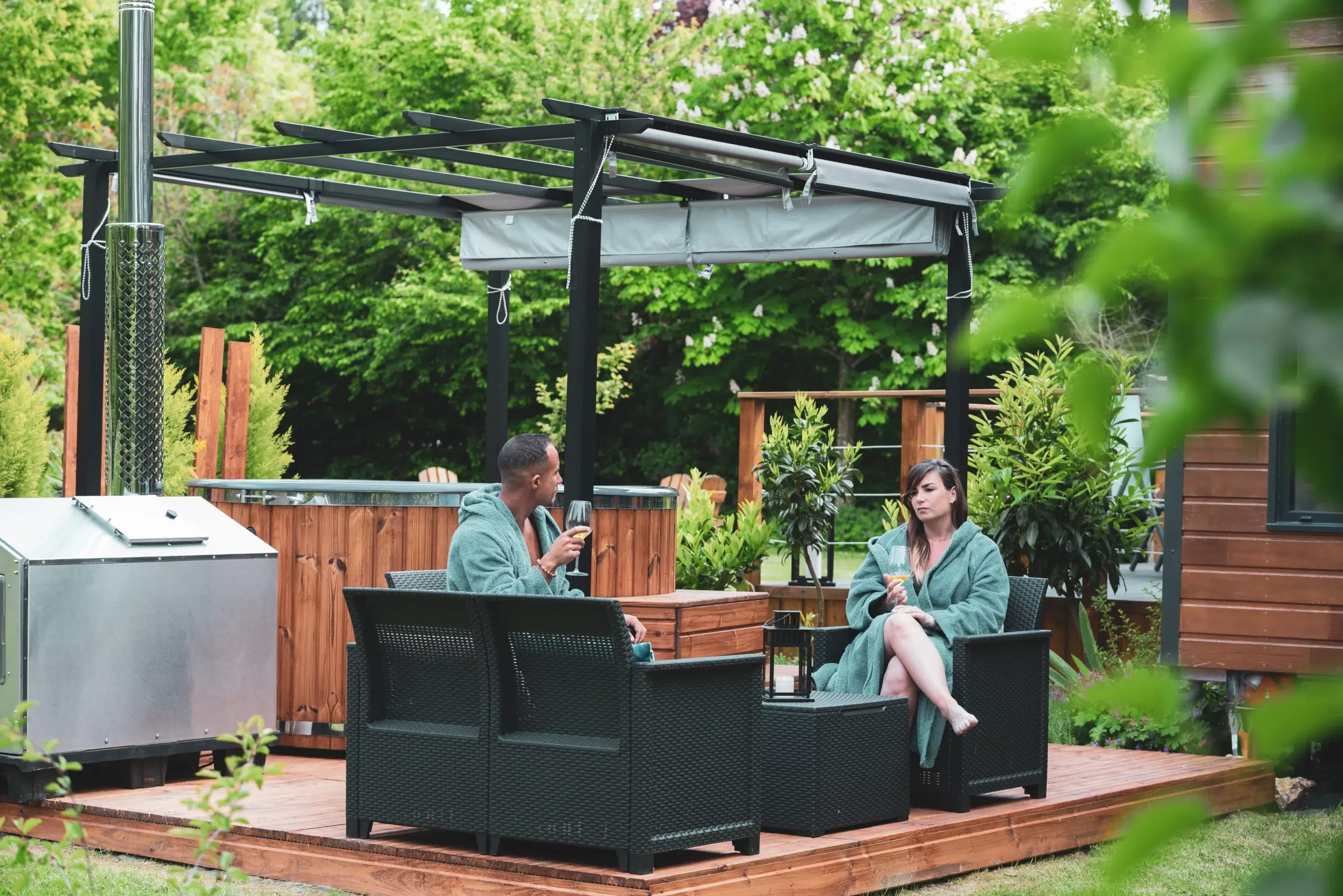 Terrasse en bois avec transats et jardin autour d’un gîte moderne